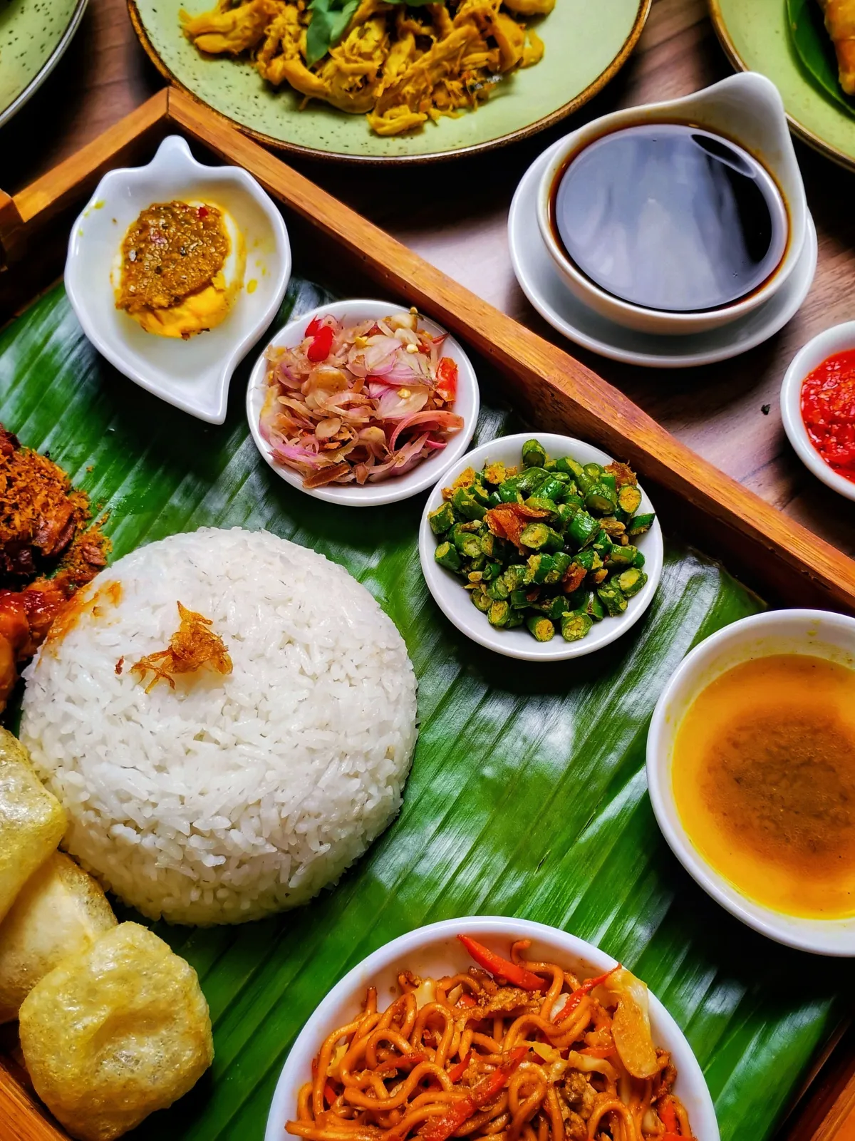 A spread of economy rice with multiple dishes — braised meat, stir-fried vegetables, tofu, and egg on white rice, typical of Malaysian chap fan hawker stalls