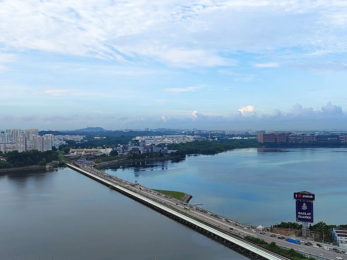 Aerial view of the Johor-Singapore Causeway with traffic and buses crossing the Strait of Johor